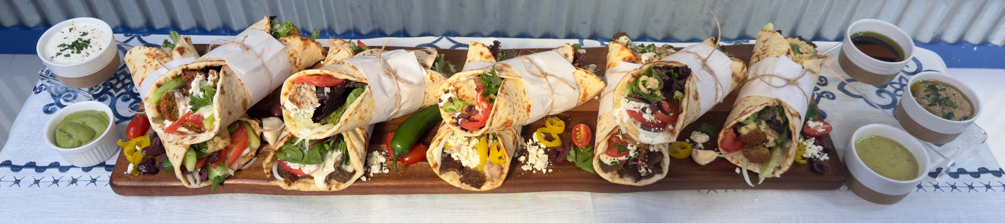 A selection of Angelina's Greek gyros and wraps arranged on a catering board